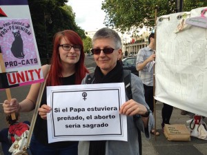 Jade and Anna outside the embassy. Anna's poster says 'If the pope could get pregnant, abortion would a sacrament' in Spanish
